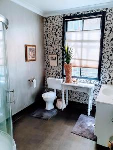 a bathroom with a toilet and a window at La Riviera Guesthouse in Riverton