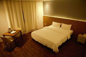 ein Hotelzimmer mit einem Bett und einem Tisch in der Unterkunft THE KOA Hotel & Spa in Angeles