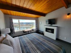 a bedroom with a bed and a fireplace and a television at Saltwater Inn in Westport