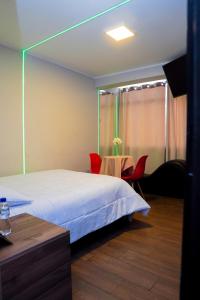 sypialnia z łóżkiem, stołem i krzesłami w obiekcie Hotel Prado w mieście Huancayo