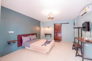 een slaapkamer met een bed, een bureau en een televisie bij Angela resort in Ban Benyaphat