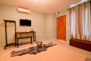 een woonkamer met een bed op de vloer en een televisie bij Angela resort in Ban Benyaphat