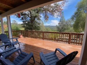 a deck with chairs and a view of the woods at Peaceful & secluded, yet close to town. in Mariposa