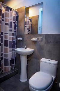 W łazience znajduje się toaleta, umywalka i lustro. w obiekcie Hotel Prado w mieście Huancayo