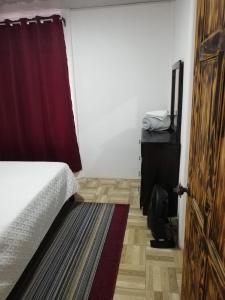 a bedroom with a bed and a door with a rug at Casa Tangara in San Isidro de El General