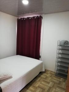1 dormitorio con cama y cortina roja en Casa Tangara, en San Isidro