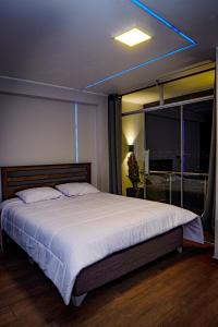 sypialnia z dużym białym łóżkiem i oknem w obiekcie Hotel Prado w mieście Huancayo