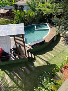 a swimming pool with two lounges and a swimming pool at Maui Maui Wellness- Taipu de Fora in Barra Grande