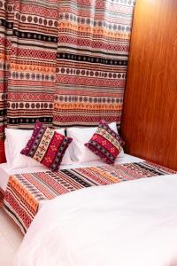 a bed with pillows on it in a room at AmberSun Travel & Tours in Ha Giang