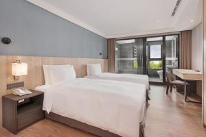 Rúm í herbergi á Four Points by Sheraton Yilan Jiaoxi