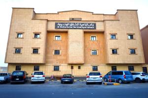 ein Gebäude mit Autos auf einem Parkplatz in der Unterkunft ركن الباهية للشقق المخدومة - مخرج 9 in Riad