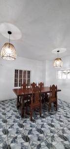 a dining room with two tables and chairs and chandeliers at Country Home in Silang Tagaytay in Silang