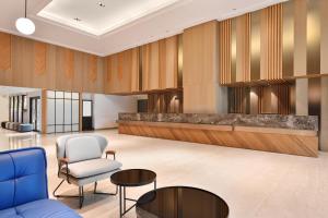 a lobby with a blue couch and a chair at Four Points by Sheraton Yilan Jiaoxi in Jiaoxi