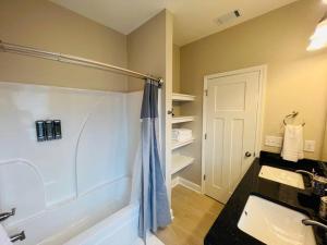 La salle de bains est pourvue d'une douche, d'un lavabo et d'une baignoire. dans l'établissement Luxury 4 Bedroom Home and private deck by MCG 6, à Augusta