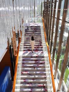 a woman walking up a staircase with wine bottles at Kerry Hotel, Beijing by Shangri-La in Beijing