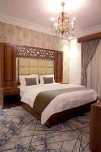 ein Schlafzimmer mit einem großen Bett und einem Kronleuchter in der Unterkunft ركن الباهية للشقق المخدومة - مخرج 9 in Riad