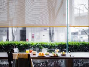 una mesa con platos de comida encima de una ventana en Mitsui Garden Hotel Okayama en Okayama