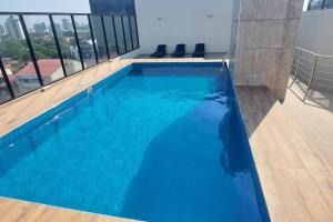 a large swimming pool with blue water in a building at Lujoso Dpto. en zona privilegiada. Amá Santa Cruz! in Santa Cruz de la Sierra