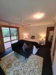 una camera con un letto e un divano di Bird Songs Getaway Accommodation a Cabbage Tree Creek