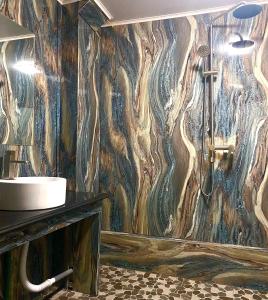 een badkamer met een wastafel en een houten muur bij AmberSun Travel & Tours in Ha Giang