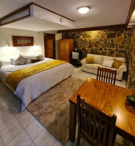 a bedroom with a large bed and a stone wall at Bird Songs Getaway Accommodation in Cabbage Tree Creek