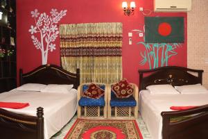 Green Leaf Guest House ColIege Road Sreemongal في سريمانغال: سريرين في غرفة بجدران حمراء