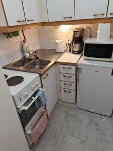 uma pequena cozinha com um fogão e um lavatório em Nest Hostel em Turku