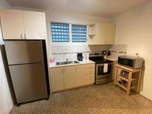a small kitchen with a sink and a refrigerator at 3 bd by airport El yunque Walk to the beach in San Juan