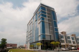 Un alto edificio bianco e blu su una strada di Pariss Hotel a Johor Bahru