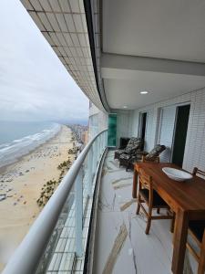 a balcony with a table and a view of the beach at Lamore in Praia Grande