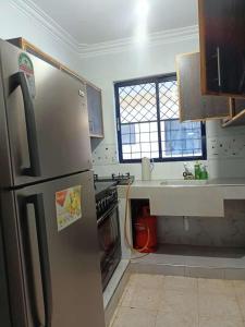 a kitchen with a stainless steel refrigerator and a sink at Mombasa , Kenya 2 bedroom Master Ensuite in Mombasa