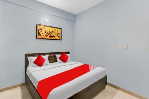 a bedroom with a red and white bed in a room at Flagship Rk Residency Near Iskcon Temple Noida in Noida