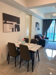 Ooak Residence in Mont Kiara, Kuala Lumpur في كوالالمبور: غرفة طعام مع طاولة وكراسي وأريكة