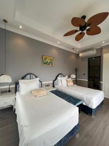 a bedroom with two beds and a ceiling fan at Sun Villa Thanh Liên Wyndham Vườn Vua Resort & Villas in Ðồng Phú