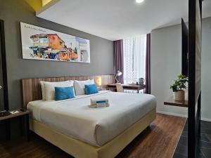 a hotel room with a large bed with blue pillows at Days Hotel & Suites by Wyndham Fraser Business Park KL in Kuala Lumpur