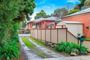 uma casa com uma cerca ao lado de uma entrada em Ballarat Holiday Homes - Bells Lane - Large Home with Double Garage - Only Minutes from Ballarat CBD - Sleeps 1 to 10 em Ballarat