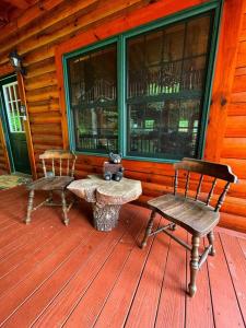 a porch with a bench and a chair on a cabin at Smokey Mountain Retreat in Waynesville