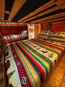 two bunk beds with colorful blankets and pillows on them at Smokey Mountain Retreat in Waynesville