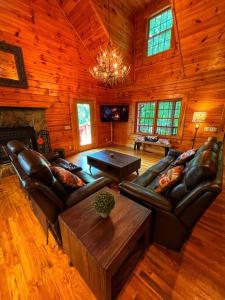 a living room with leather furniture and a chandelier at Smokey Mountain Retreat in Waynesville