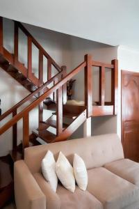 uma sala de estar com um sofá e uma escada em Olive Home Arusha em Nasulo