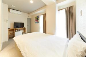 a bedroom with a white bed and a television at GATE STAY hotel Osaka Namba in Osaka