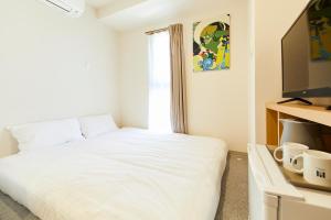 a bedroom with a white bed and a window at GATE STAY hotel Osaka Namba in Osaka