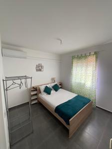 ein Schlafzimmer mit einem großen Bett und einem Fenster in der Unterkunft Évasion tropicale Villa de rêve avec piscine à Petit Bourg in Petit-Bourg