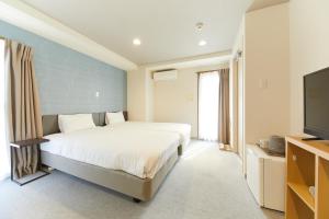 a bedroom with a bed and a flat screen tv at GATE STAY hotel Osaka Namba in Osaka
