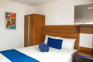 a hotel room with a bed with a blue pillow at La Casa Azul (Zona de Hospitales) in Mexico City