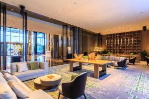 a hotel lobby with couches and a table at Wanda Realm Heshan in Jiangmen