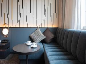 - un salon avec un canapé bleu et une table dans l'établissement Mitsui Garden Hotel Shiodome Italia-gai - Tokyo, à Tokyo
