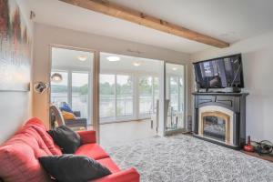 sala de estar con sofá rojo y chimenea en Shack des Lacs - Chalet sur le bord de l'eau avec spa, en Trois-Lacs