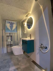 La salle de bains est pourvue d'un lavabo, de toilettes et d'un miroir. dans l'établissement 澎湖串門子輕旅民宿Penghu Chuanmenzi Light B&B, à Magong