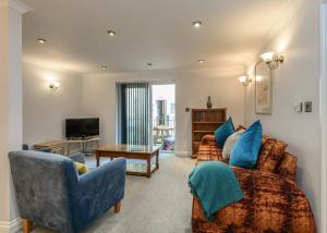 a living room with two couches and a television at Beachcombers in Newquay Bay Resort